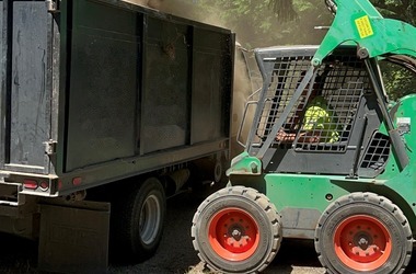 Skid steer loading a dump truck on an earthwork job